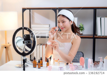Young asian woman presenting and review cosmetic product with excitement on social media. Young asian woman presenting and review cosmetic product with excitement on social media. 136192714