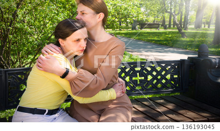 Two girls hug one another 136193045