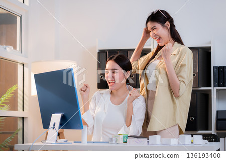 Two asian businesswoman team celebrate success with excited for cosmetic packaging design project. 136193400