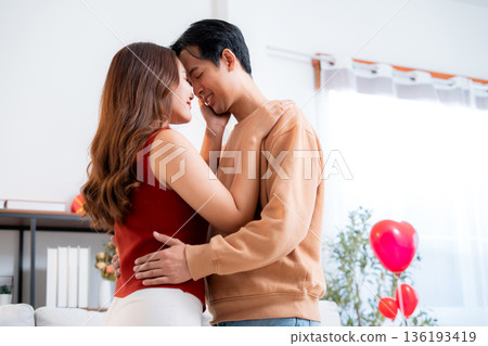 Romantic asian couple standing with head touch, feeling love and tenderness at home. 136193419