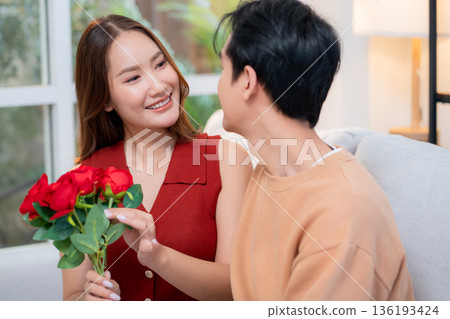 Happy asian woman receiving rose bouquet from boyfriend with celebrating Valentine's Day. 136193424