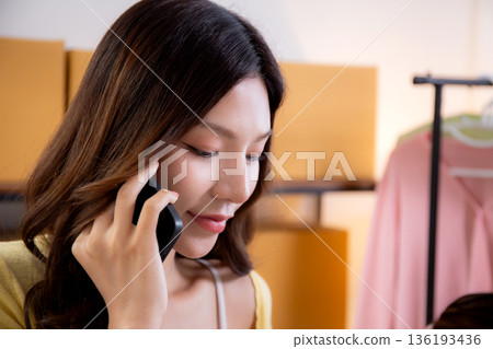 Young asian woman talking smartphone check order, online seller, small business or startup. 136193436