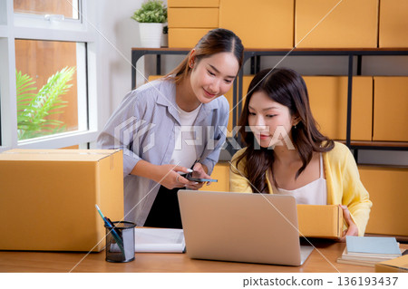 Two asian woman working in small business online store, online seller. Two asian woman working in small business online store, online seller. 136193437