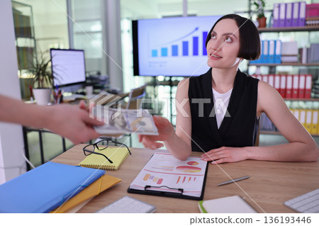 Business transaction takes place in a modern office setting during a busy workday 136193446
