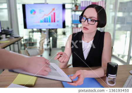 Professional discussion between a businesswoman and her colleague during a strategy meeting in a modern office setting 136193450