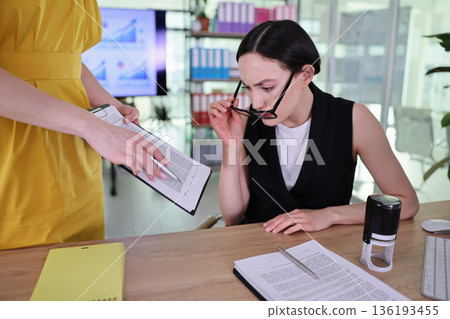Meeting in a modern office environment, focusing on teamwork and presentations between bright women Meeting in a modern office environment, focusing on teamwork and presentations between bright women 136193455