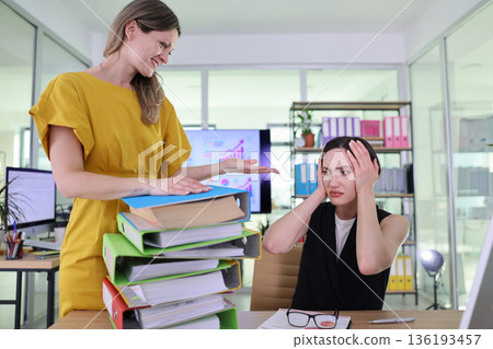 Stressful office environment with overwhelmed employee and supportive colleague in vibrant workspace Stressful office environment with overwhelmed employee and supportive colleague in vibrant workspace 136193457