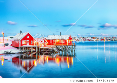 Outstanding evening cityscape of Reine town. Red rorbuers on the shoore of Reinefjorden. 136193576