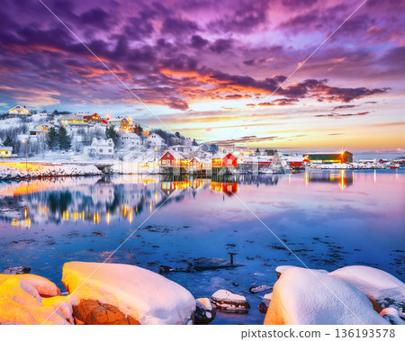 Outstanding evening cityscape of Reine town. Red rorbuers on the shoore of Reinefjorden. Outstanding evening cityscape of Reine town. Red rorbuers on the shoore of Reinefjorden. 136193578
