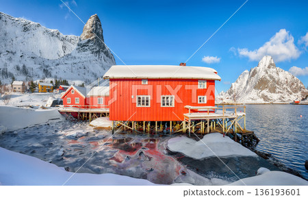 Outstanding winter sunny view on Reine Village and Gravdalbukta bay with cracked ice. Outstanding winter sunny view on Reine Village and Gravdalbukta bay with cracked ice. 136193601