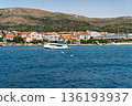Modern yacht cruising along Dalmatian coast near Split with mountains and waterfront houses 136193937
