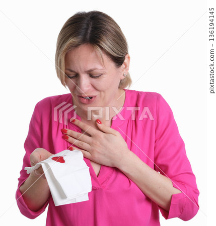 Woman reacts with surprise while holding a tissue stained with red, conveying intense emotions in a simple setting Woman reacts with surprise while holding a tissue stained with red, conveying intense emotions in a simple setting 136194145