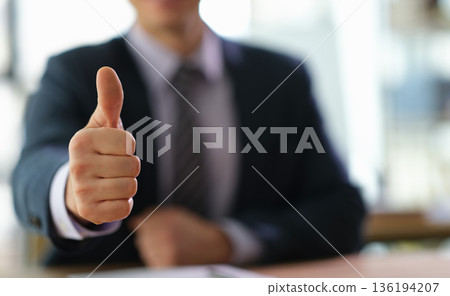 Success is celebrated with a confident thumbs-up gesture in a bright office setting during a productive business meeting 136194207