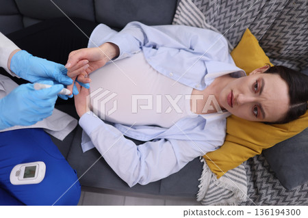 Feeling uncertain during a prenatal check-up with a healthcare professional in a cozy living room setting Feeling uncertain during a prenatal check-up with a healthcare professional in a cozy living room setting 136194300