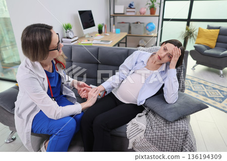 Doctor provides care and comfort to expectant mother during a maternity consultation in a serene and modern setting 136194309
