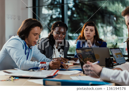 Business people collaborating during busy corporate meeting 136194576