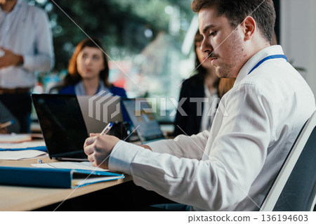 Business people collaborating during busy corporate meeting Business people collaborating during busy corporate meeting 136194603