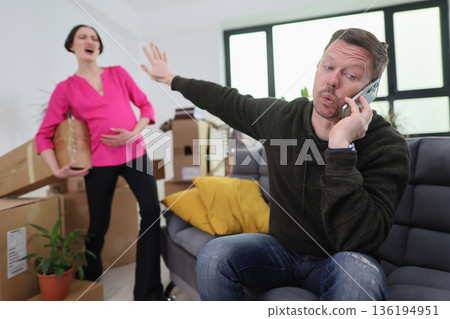 Couple navigating stress while moving into a new home, showcasing a mix of excitement and frustration during the busy transition Couple navigating stress while moving into a new home, showcasing a mix of excitement and frustration during the busy transition 136194951