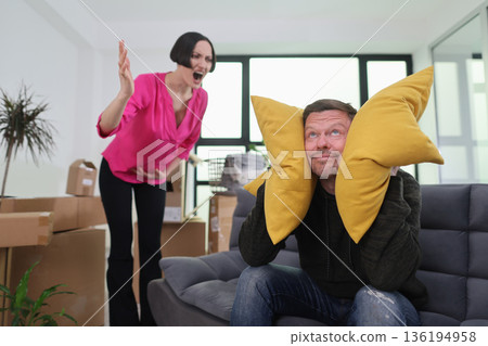 Couple navigating a lively discussion in their new apartment surrounded by unpacked boxes 136194958