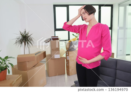 Excitement and anticipation fill the air as a mother-to-be navigates her new home surrounded by moving boxes Excitement and anticipation fill the air as a mother-to-be navigates her new home surrounded by moving boxes 136194970
