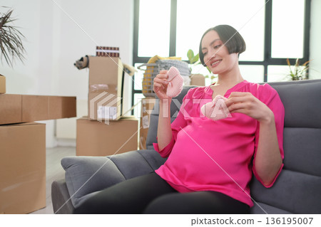 Expecting joy in a cozy space while crafting sweet baby booties during a sunny afternoon 136195007