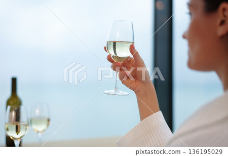 Sipping white wine by the serene ocean view during a peaceful afternoon retreat Sipping white wine by the serene ocean view during a peaceful afternoon retreat 136195029