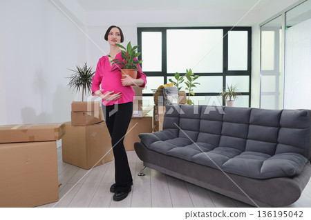 Joyful expectations in a bright new home filled with life and promise as a woman prepares to embrace motherhood Joyful expectations in a bright new home filled with life and promise as a woman prepares to embrace motherhood 136195042