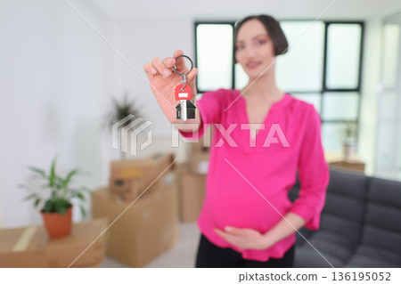 New beginnings unfold as a pregnant woman holds keys in her bright living room filled with boxes New beginnings unfold as a pregnant woman holds keys in her bright living room filled with boxes 136195052