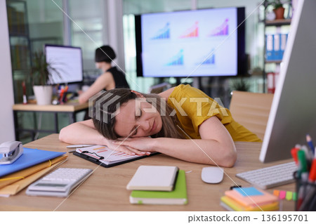 Exhausted professional taking a break at a busy office during the day while analyzing performance data on screens Exhausted professional taking a break at a busy office during the day while analyzing performance data on screens 136195701