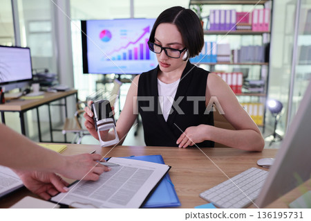 Business meeting reveals collaboration and focus in a modern office setting with charts and documents 136195731