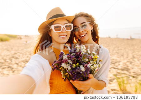 Two pretty friends women making selfie on beach, light and bright summer colors. Friends together Two pretty friends women making selfie on beach, light and bright summer colors. Friends together 136195798