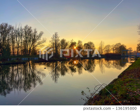 Rijkevorsel, Antwerpse Kempen, Belgium, sunset rim light through riverside trees with reflections 136195800