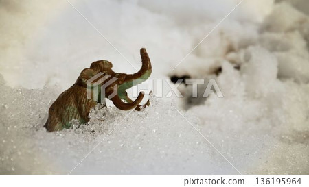 Woolly mammoth toy navigating snowy ice age landscape Woolly mammoth toy navigating snowy ice age landscape 136195964