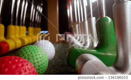 Miniature golf putters and colored balls awaiting players 136196033