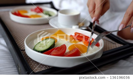 Close-up of a dinner tray with delicious food in the bedroom. Breakfast on the bed in the hotel room. Breakfast at the hotel, in the room. 136196036