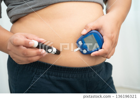 Asian woman injecting herself diabetes injecting insulin in stomach at home. Asian woman injecting herself diabetes injecting insulin in stomach at home. 136196321