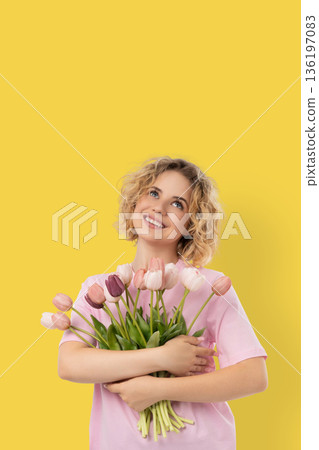 A woman holds flowers and smiles for the holiday 136197083