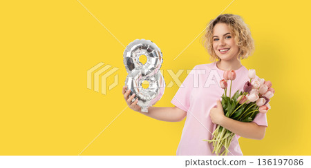 A woman holds flowers and a number 8 balloon for Women's Day A woman holds flowers and a number 8 balloon for Women's Day 136197086