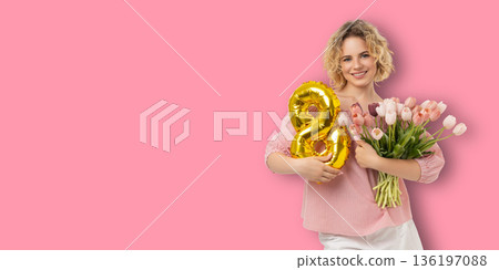 Woman holding flowers and balloon while celebrating Women's Day Woman holding flowers and balloon while celebrating Women's Day 136197088