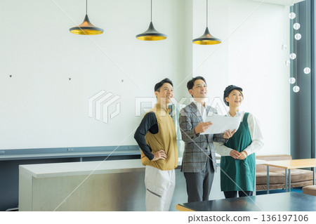 A male craftsman wearing an air-conditioned suit having a meeting while looking at documents 136197106