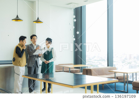一位身穿空調西裝的男工匠正在開會，同時查看文件。 136197109