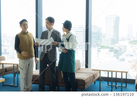 一位身穿空調西裝的男工匠正在開會，同時查看文件。 136197110