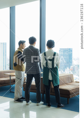 A male craftsman wearing an air-conditioned suit having a meeting while looking at documents 136197118