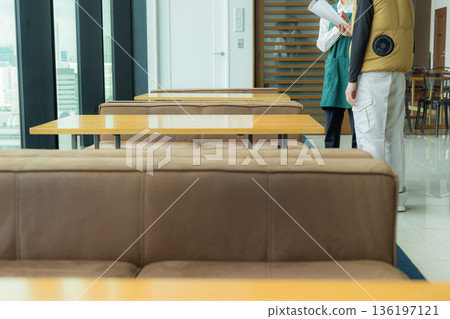 一位身穿空調西裝的男工匠正在開會，同時查看文件。 136197121