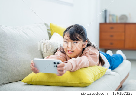 玩智慧型手機的小學生女孩 玩智慧型手機的小學生女孩 136197223