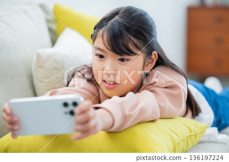 玩智慧型手機的小學生女孩 玩智慧型手機的小學生女孩 136197224