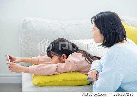 玩智慧型手機的小學生女孩 136197286