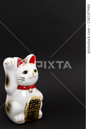 A white beckoning cat placed on a black background A white beckoning cat placed on a black background 136197466