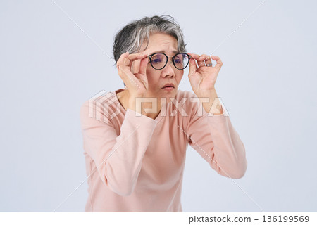 Senior woman suffering from declining eyesight Senior woman suffering from declining eyesight 136199569