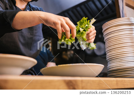 Chef hands preparing fresh green salad in kitchen 136200253